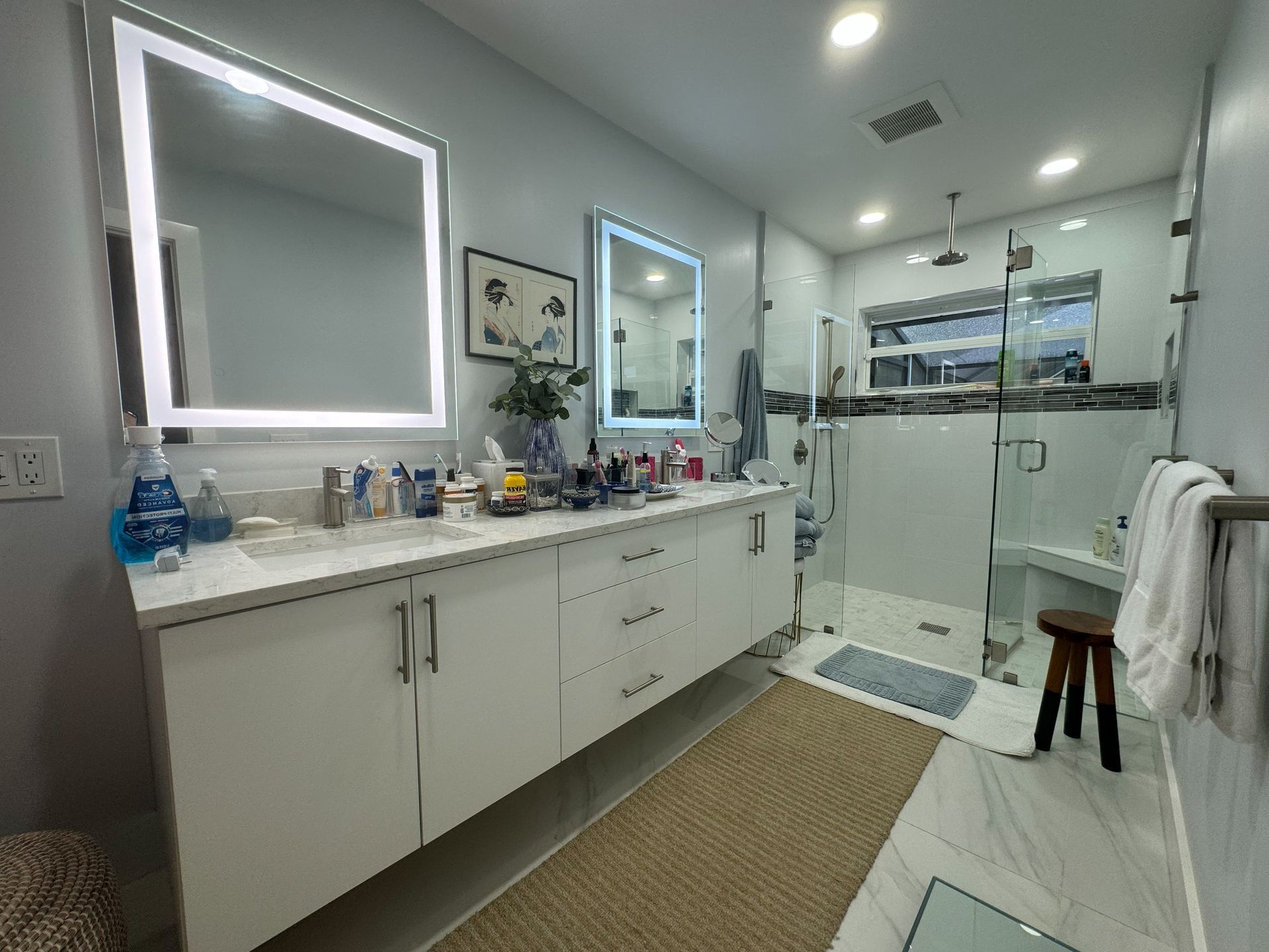 A bathroom with a double vanitynd a walk in shower.