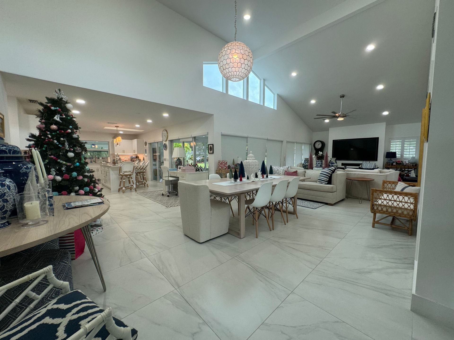 There is a christmas tree in the middle of the living room.