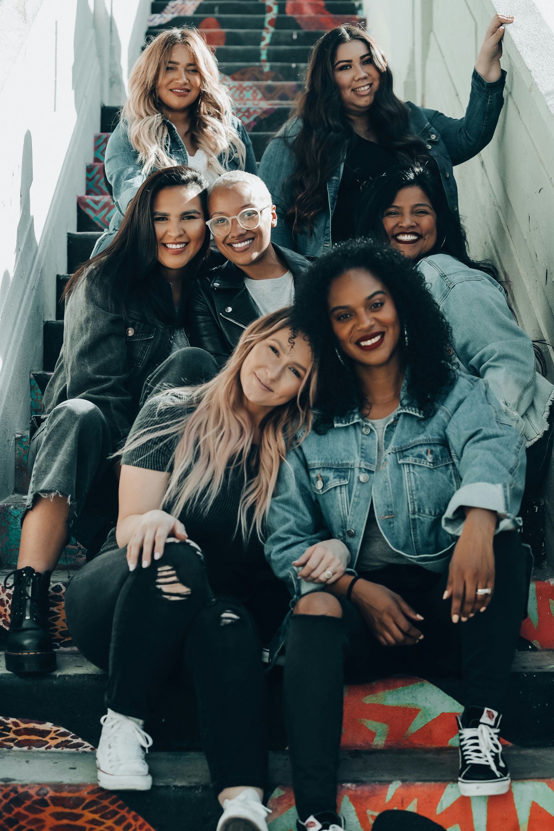 A group of women are posing for a picture on a set of stairs.