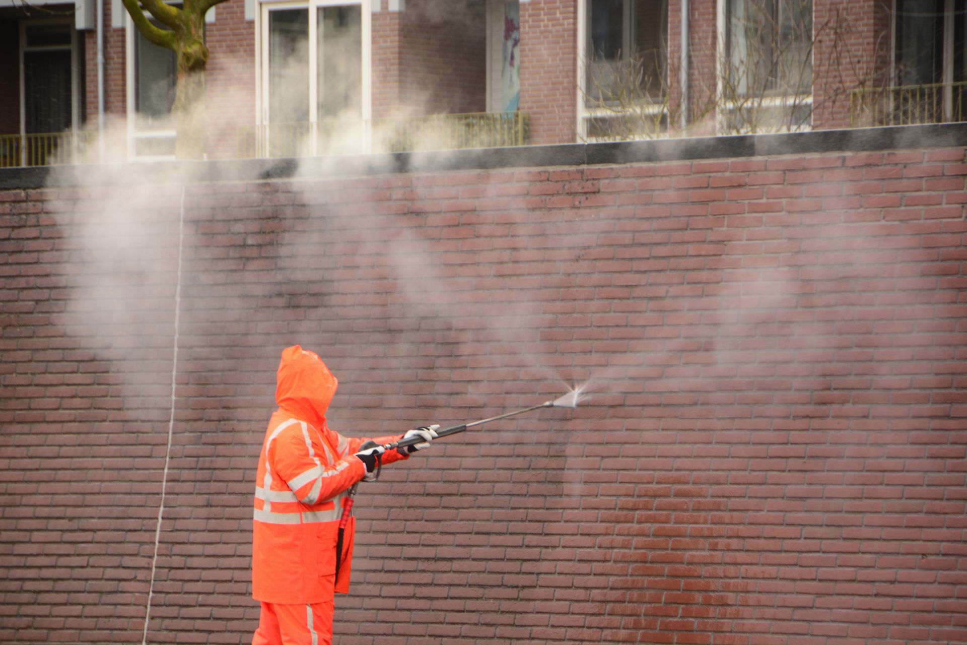 Pressure washing a brick wall in Chattanooga, TN.