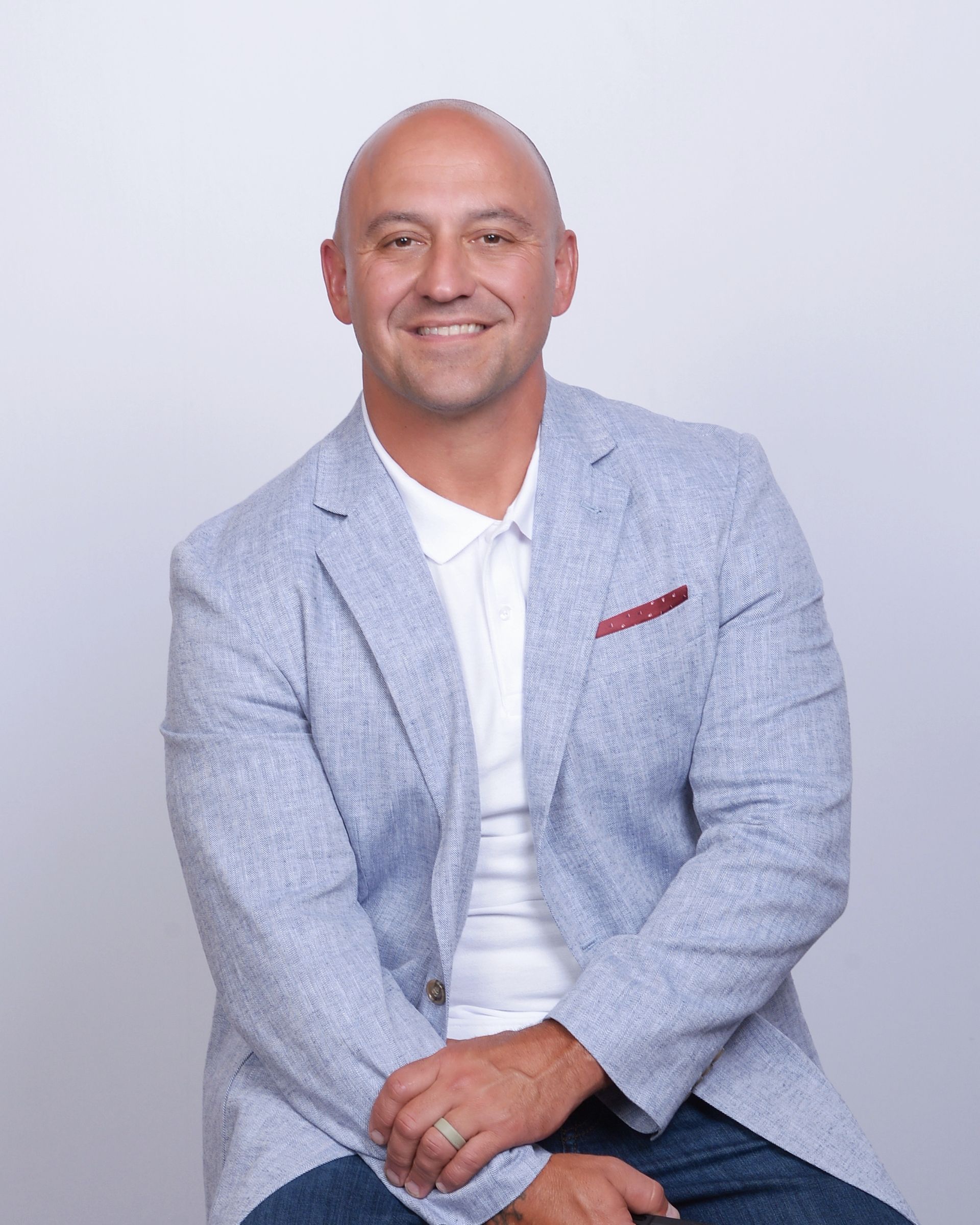 A man is sitting in a chair in front of a brick wall.