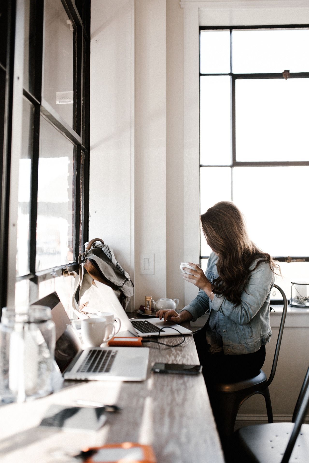 girl working at desk with coffee in hand