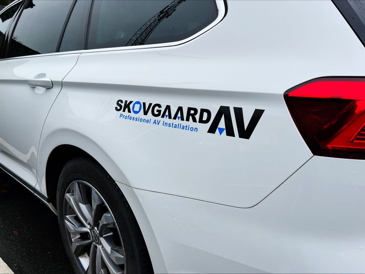 A white car with skovgaard av written on the side