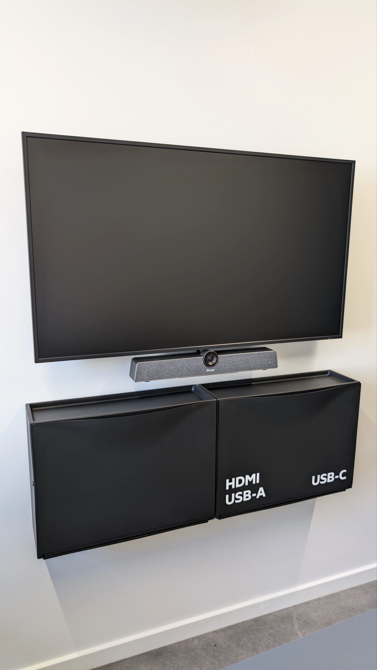 A flat screen tv is mounted on a wall next to two speakers.