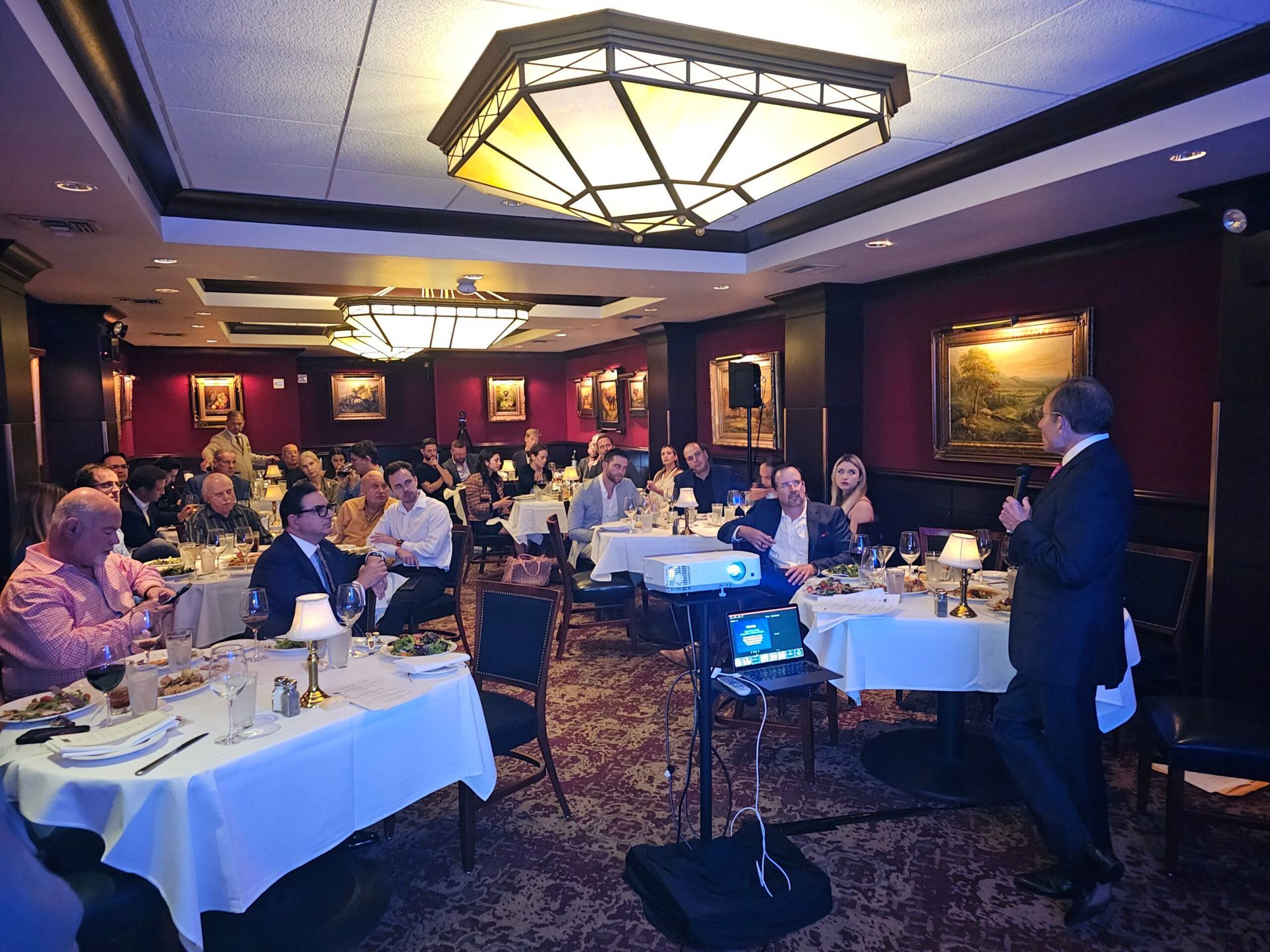 A man is giving a presentation to a group of people in a restaurant.
