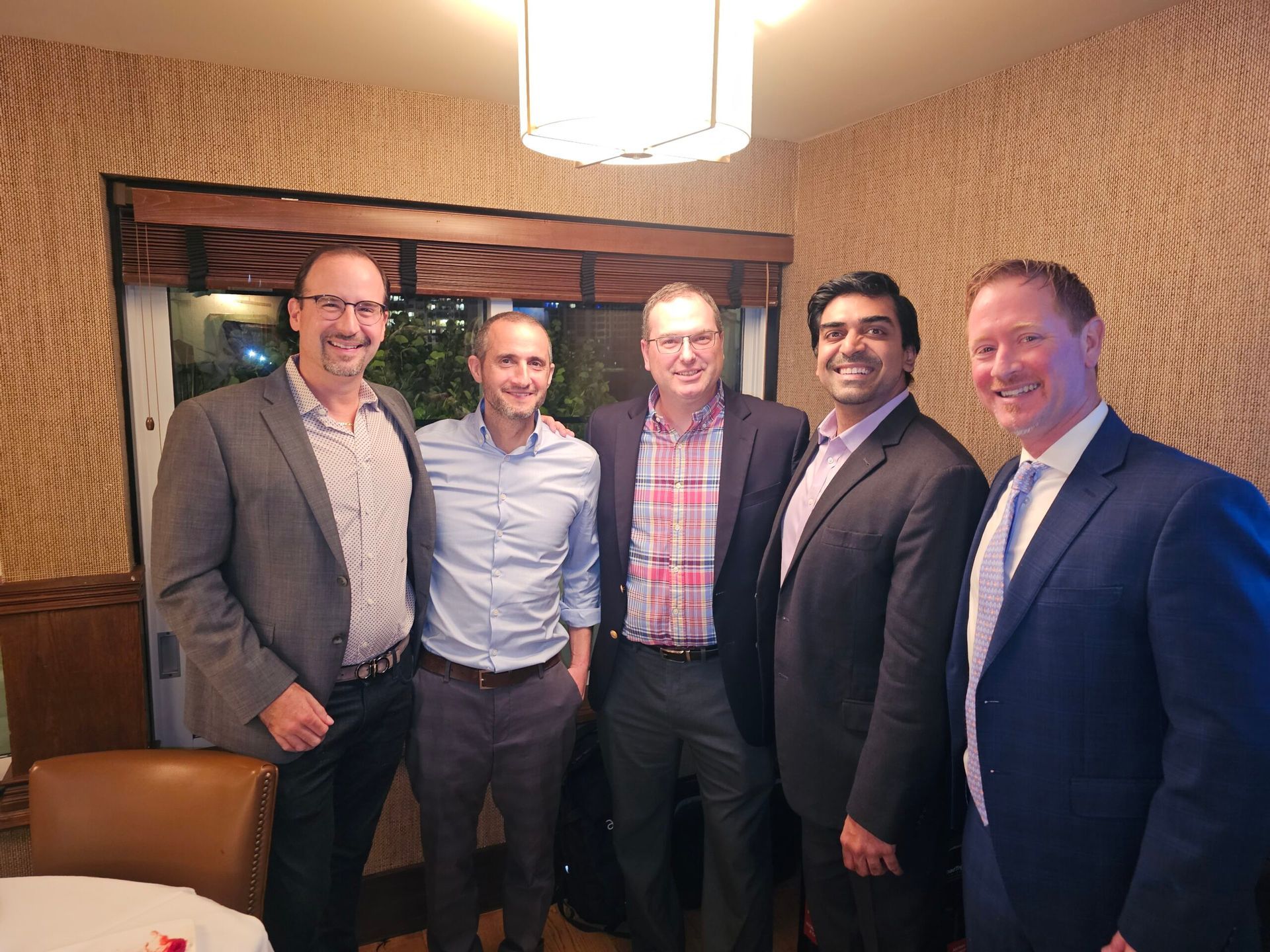 A group of men are posing for a picture in a room.