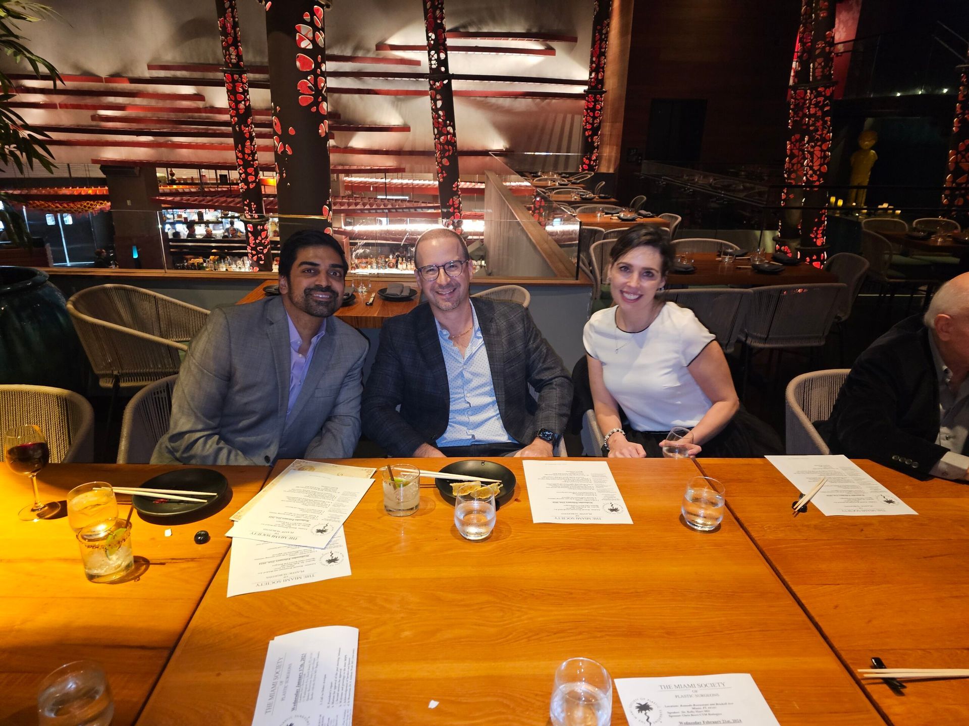 Three people are sitting at a table in a restaurant