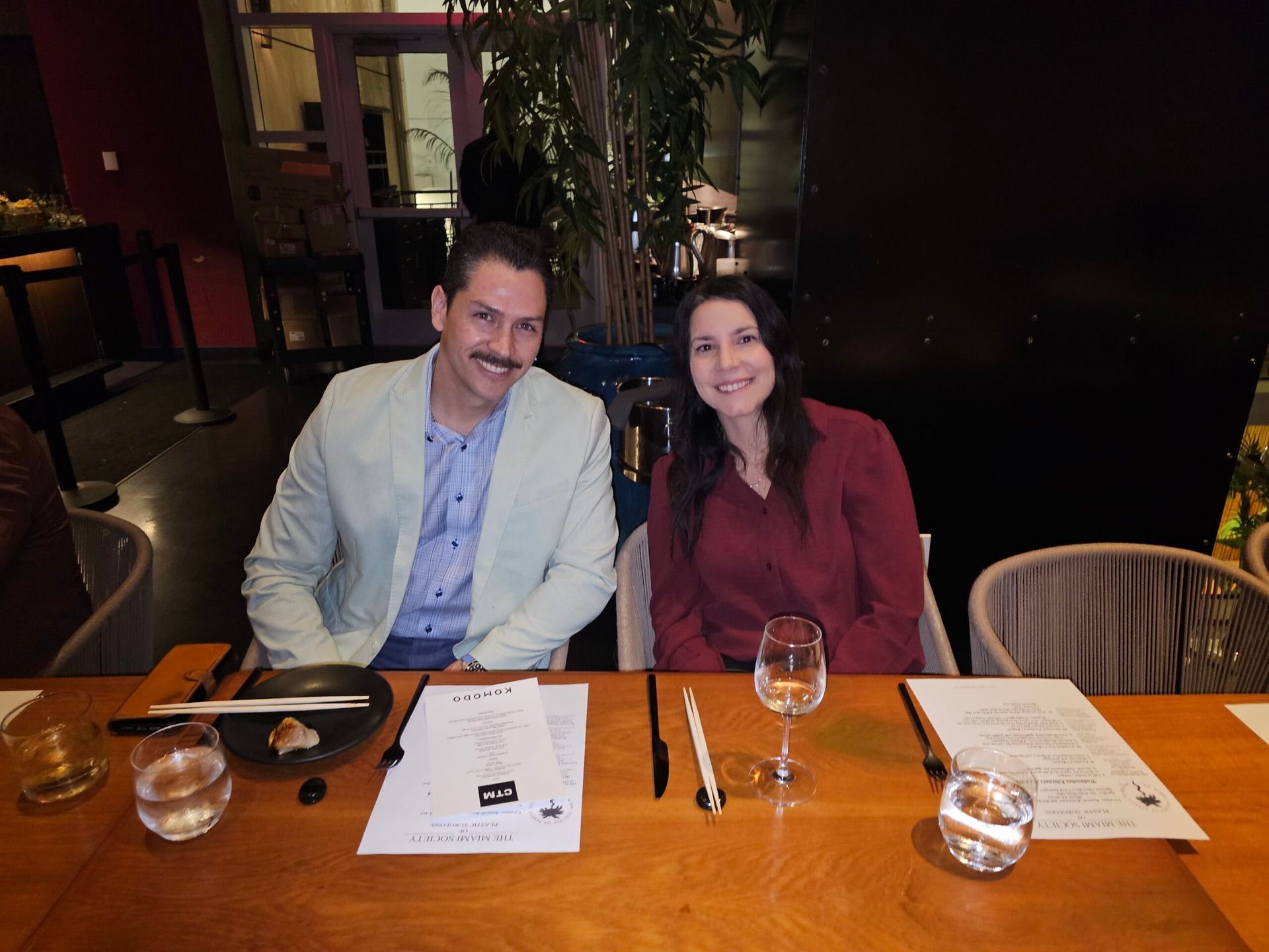 A man and a woman are sitting at a table in a restaurant.