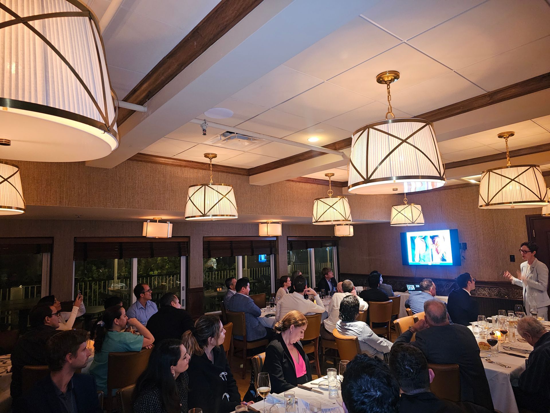 A group of people are sitting at tables in a restaurant.