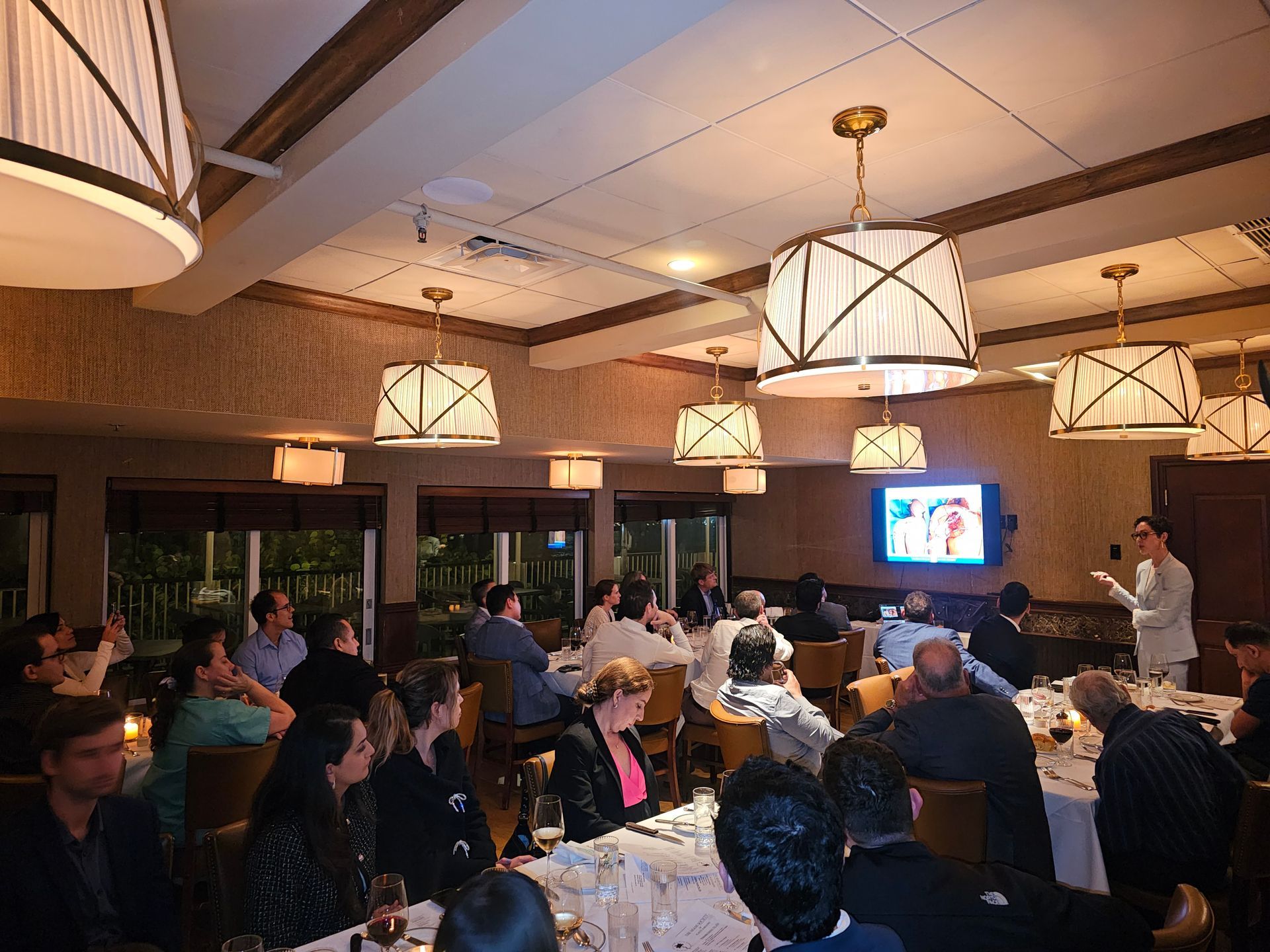 A man is giving a presentation to a group of people in a restaurant.