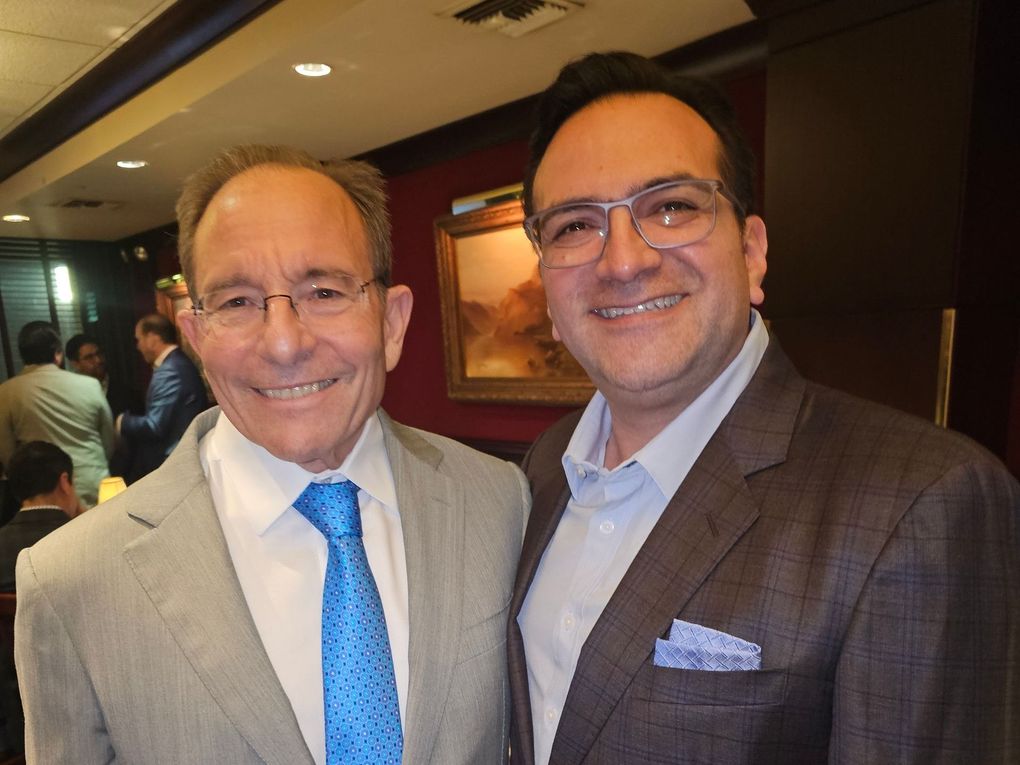 Two men in suits and ties are posing for a picture