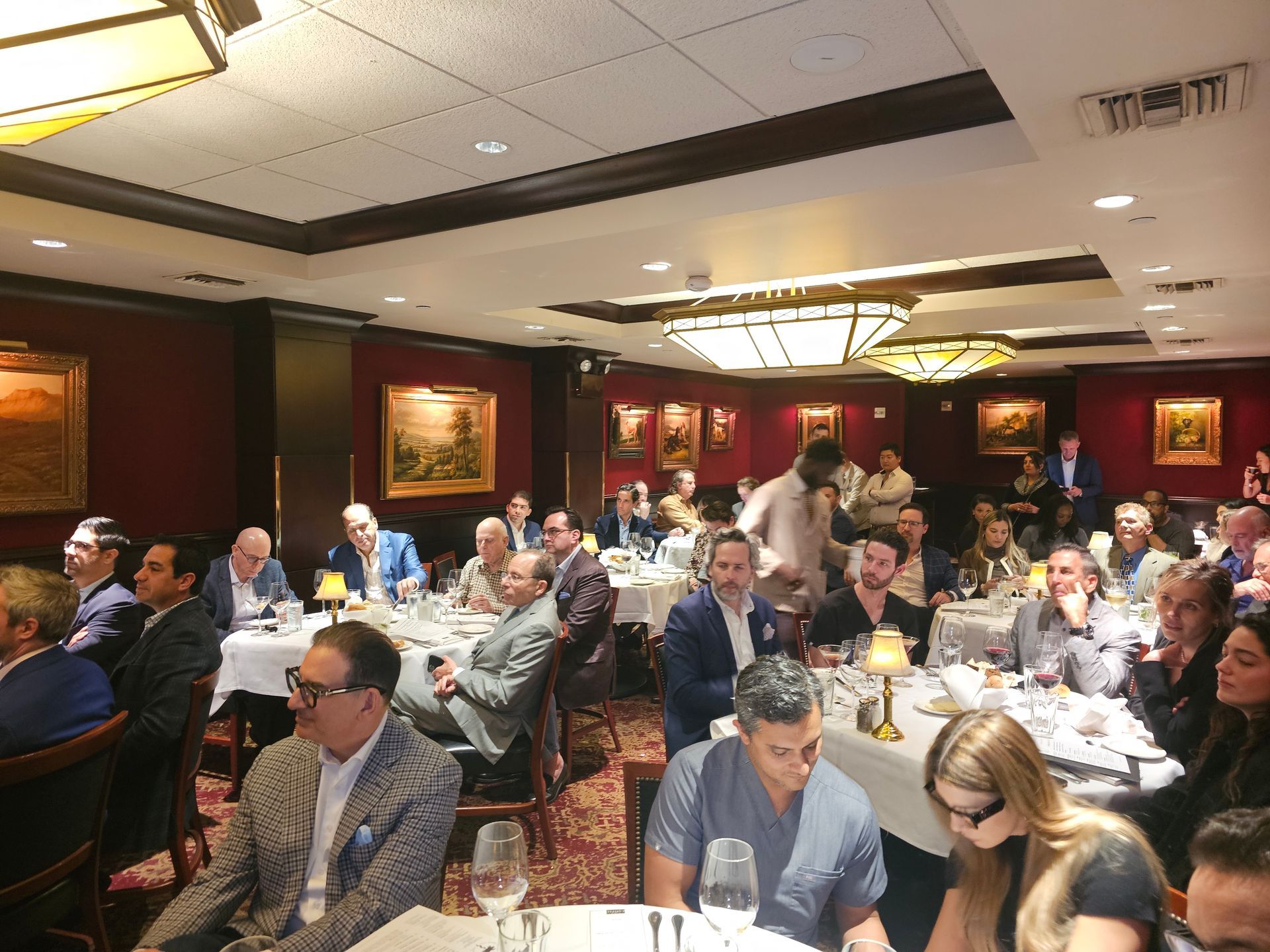 A large group of people are sitting at tables in a restaurant.
