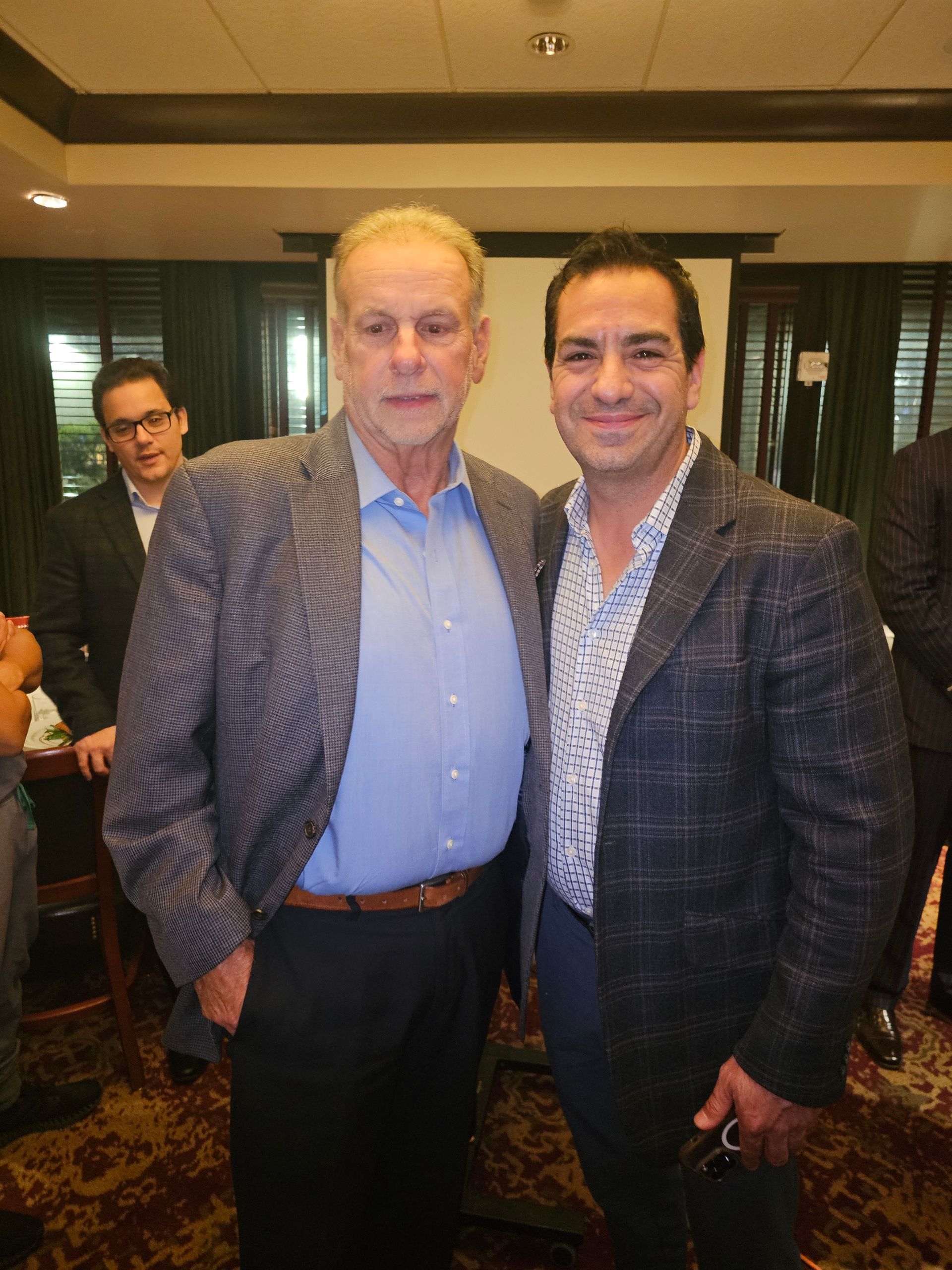 Two men are posing for a picture together in a room.