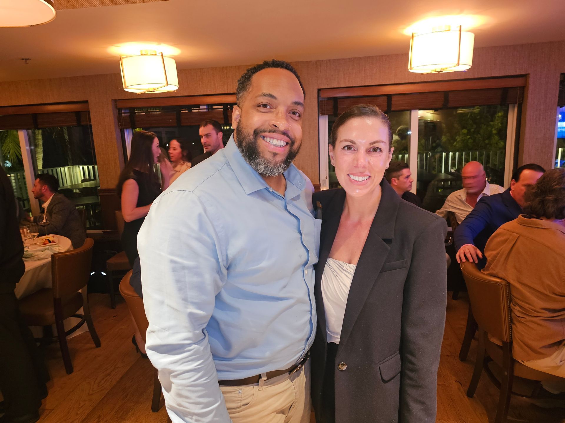 A man and a woman are posing for a picture in a restaurant.