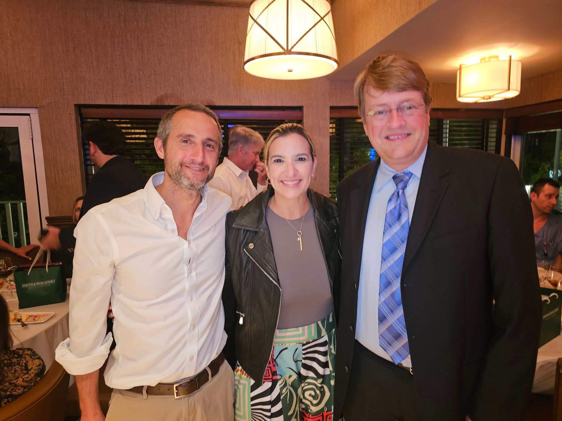 Three people are posing for a picture in a restaurant.