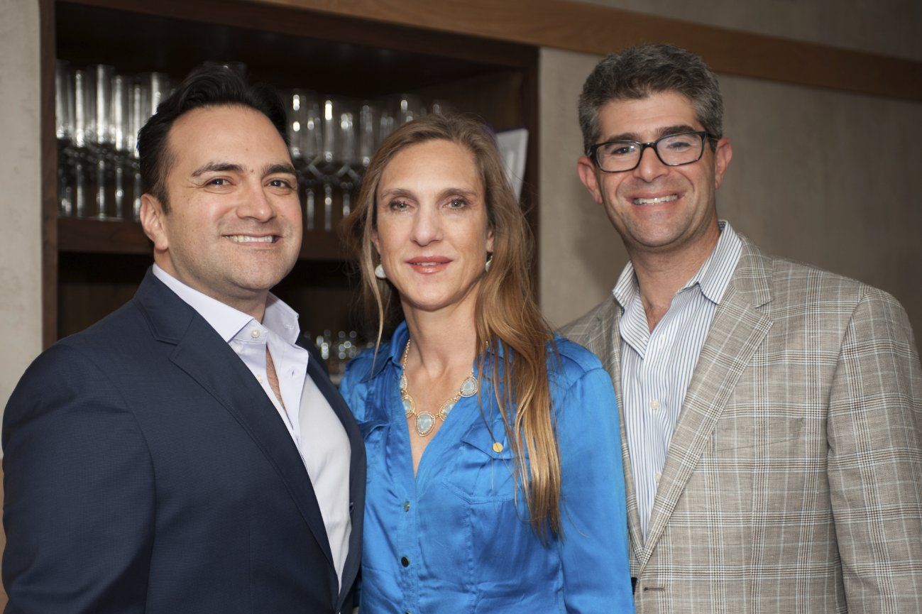 A man in a suit and a woman in a blue shirt are posing for a picture.