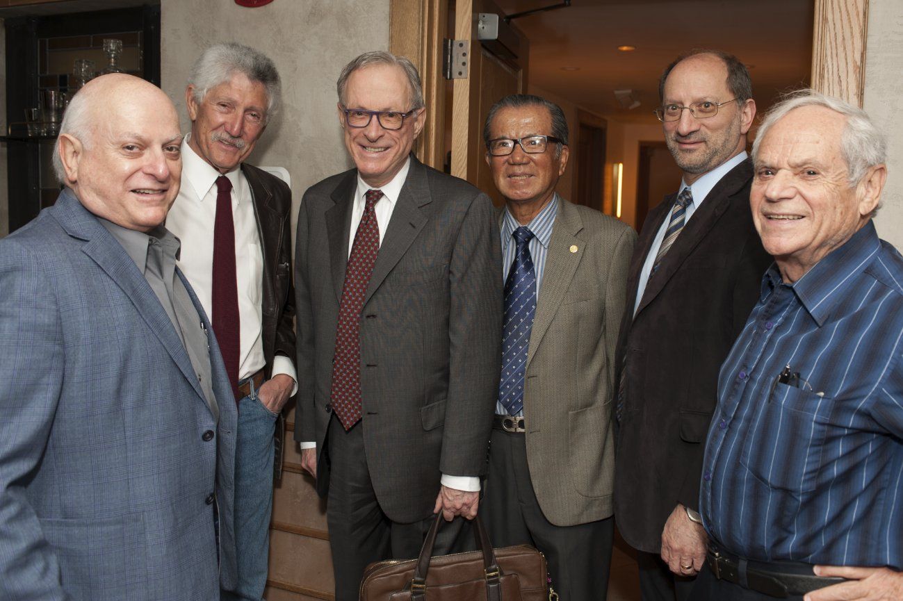 A group of men in suits and ties are posing for a picture