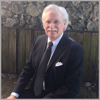 A man in a suit and tie is sitting on a wooden bench