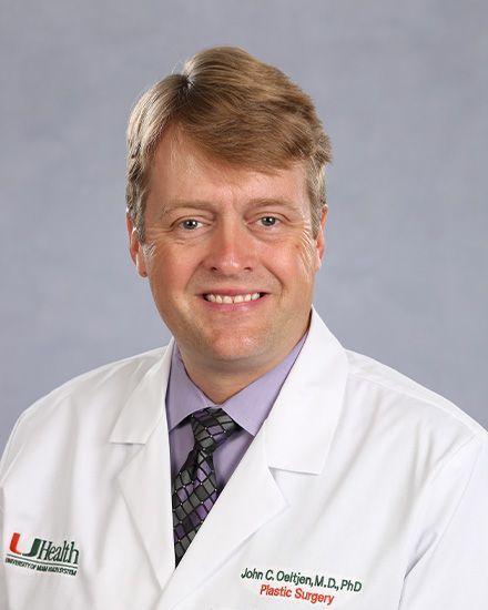 A man in a suit and tie is smiling for the camera.