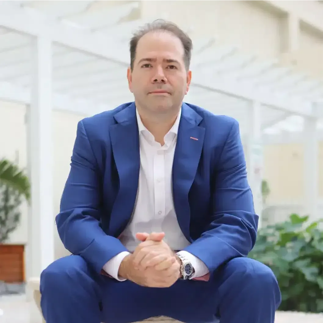 A man in a suit and tie is smiling for the camera.