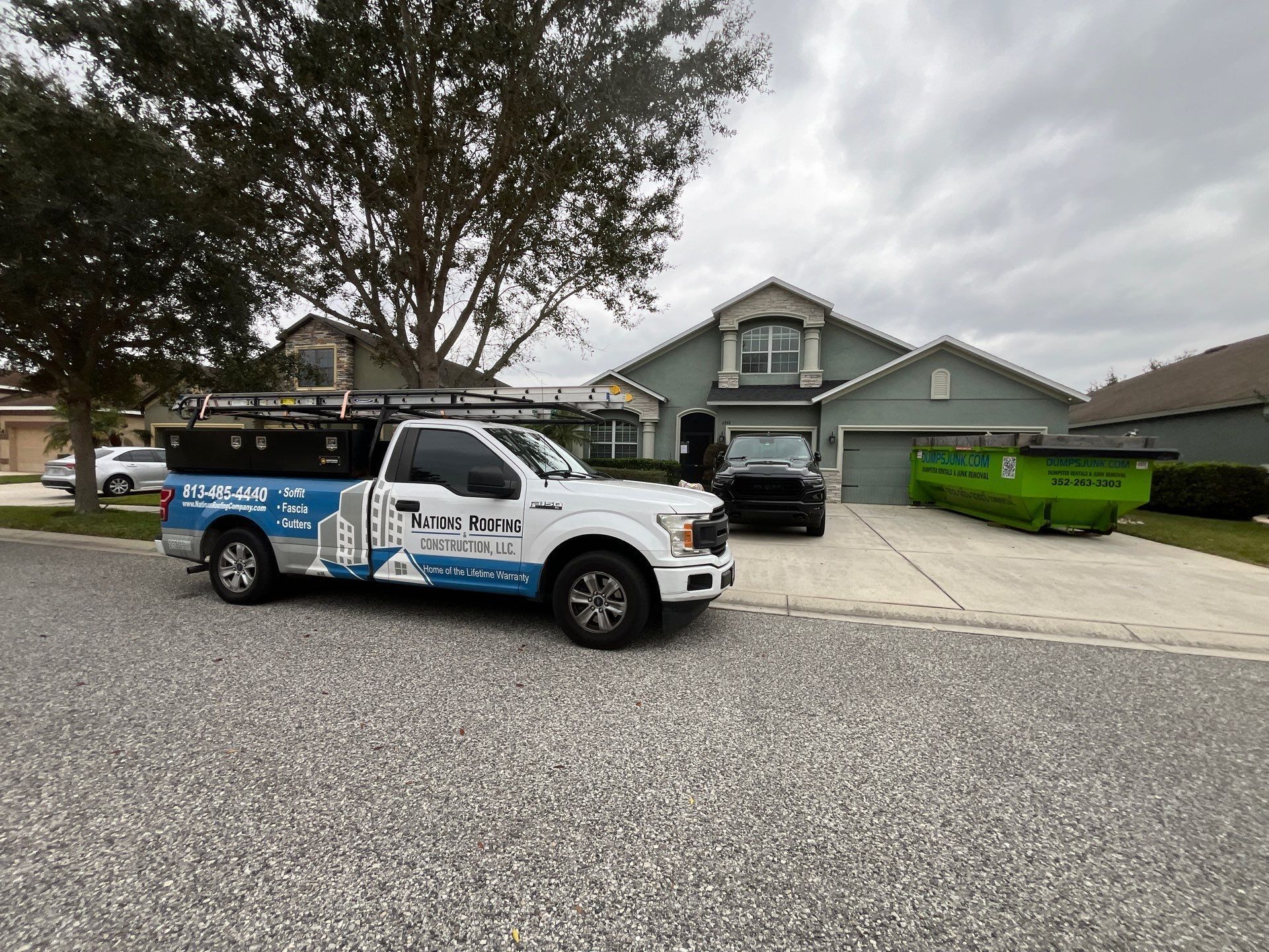 Street view of a completed roof replacement in the Oak Creek community of Wesley Chapel, FL featuring CertainTeed Landmark Charcoal Black architectural shingles installed by Nations Roofing & Construction.