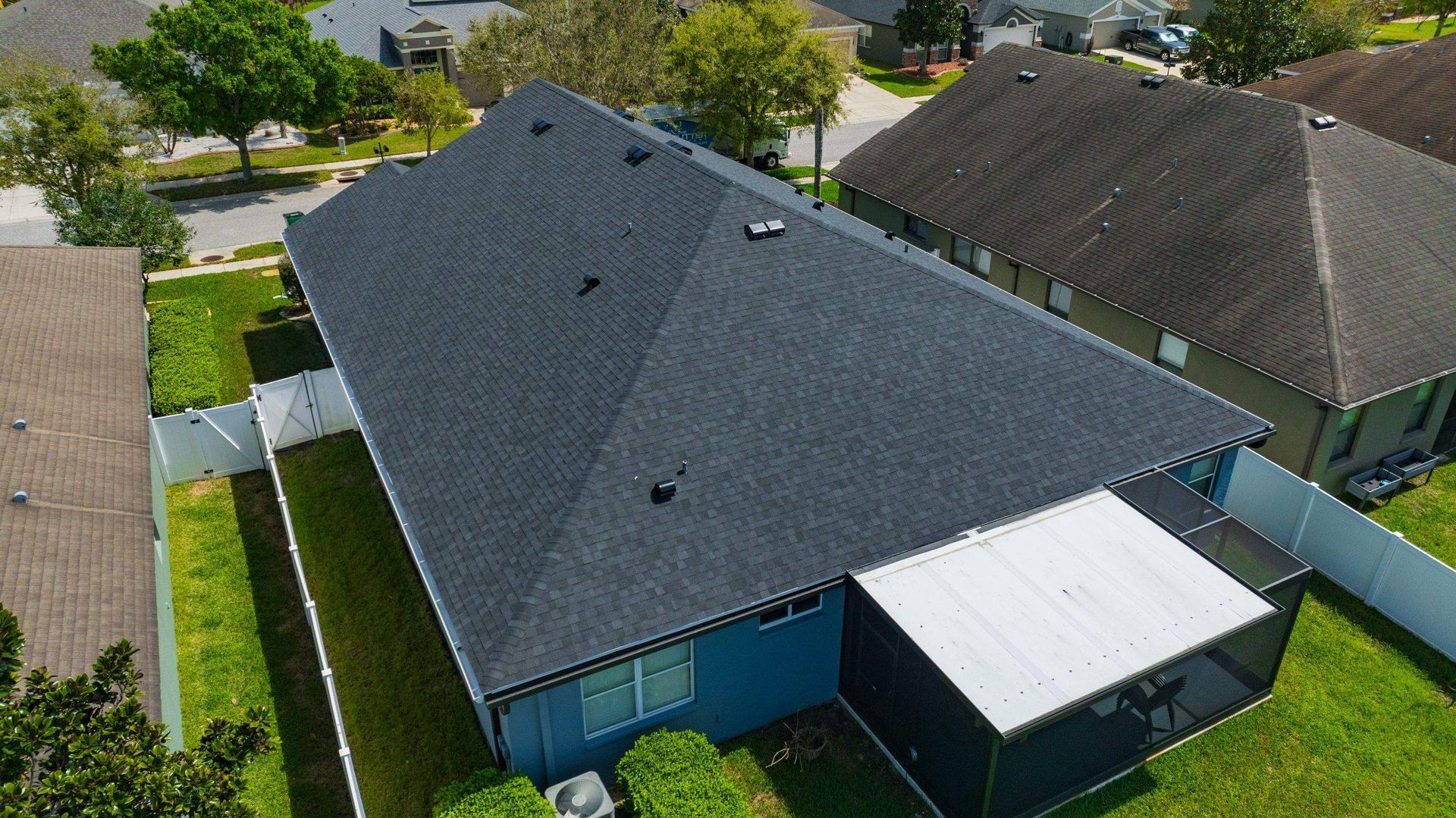 Aerial view of a completed CertainTeed Landmark Charcoal Black asphalt shingle roof replacement on a home in the Oak Creek neighborhood of Wesley Chapel, Florida.