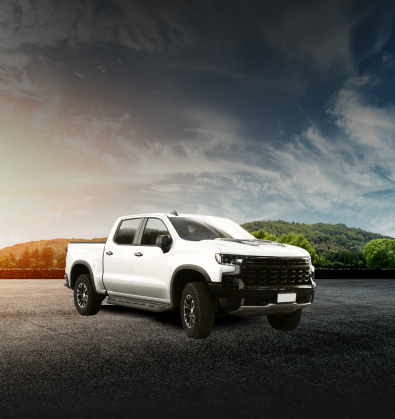 White pickup truck on asphalt with a mountain backdrop under a cloudy sky | The SouthSide Garage