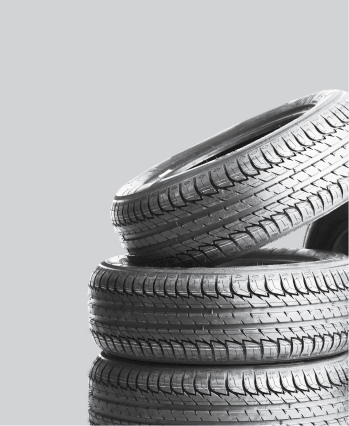 Stack of three vehicle tires against a gray background | The SouthSide Garage