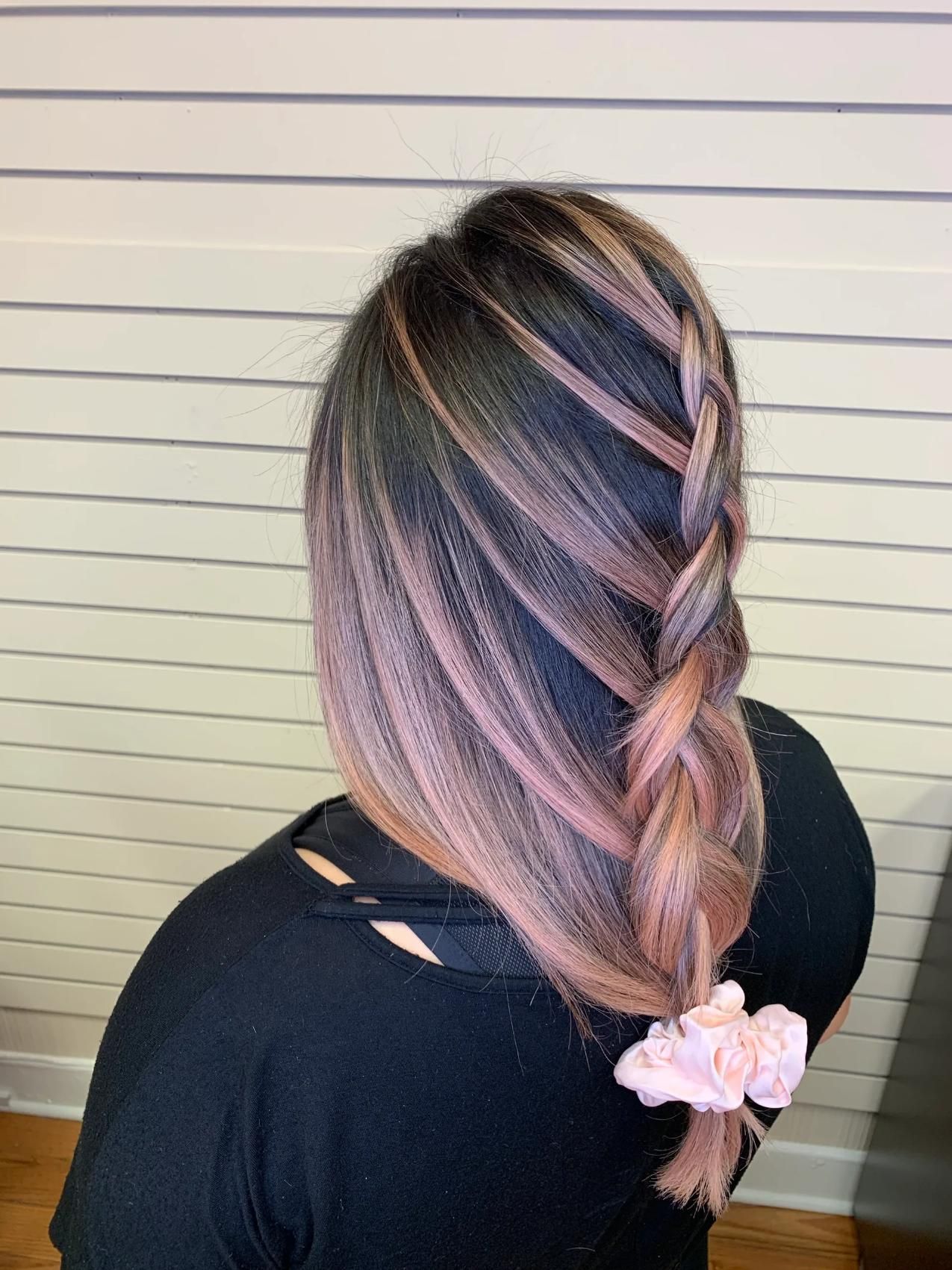 Woman with dark hair, side braid, and pink highlights. A pink scrunchie secures the braid.