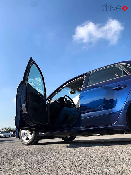 Schadeadviseur van Drivex zit in een blauwe auto om te kijken of er ook schade in het voertuig is.