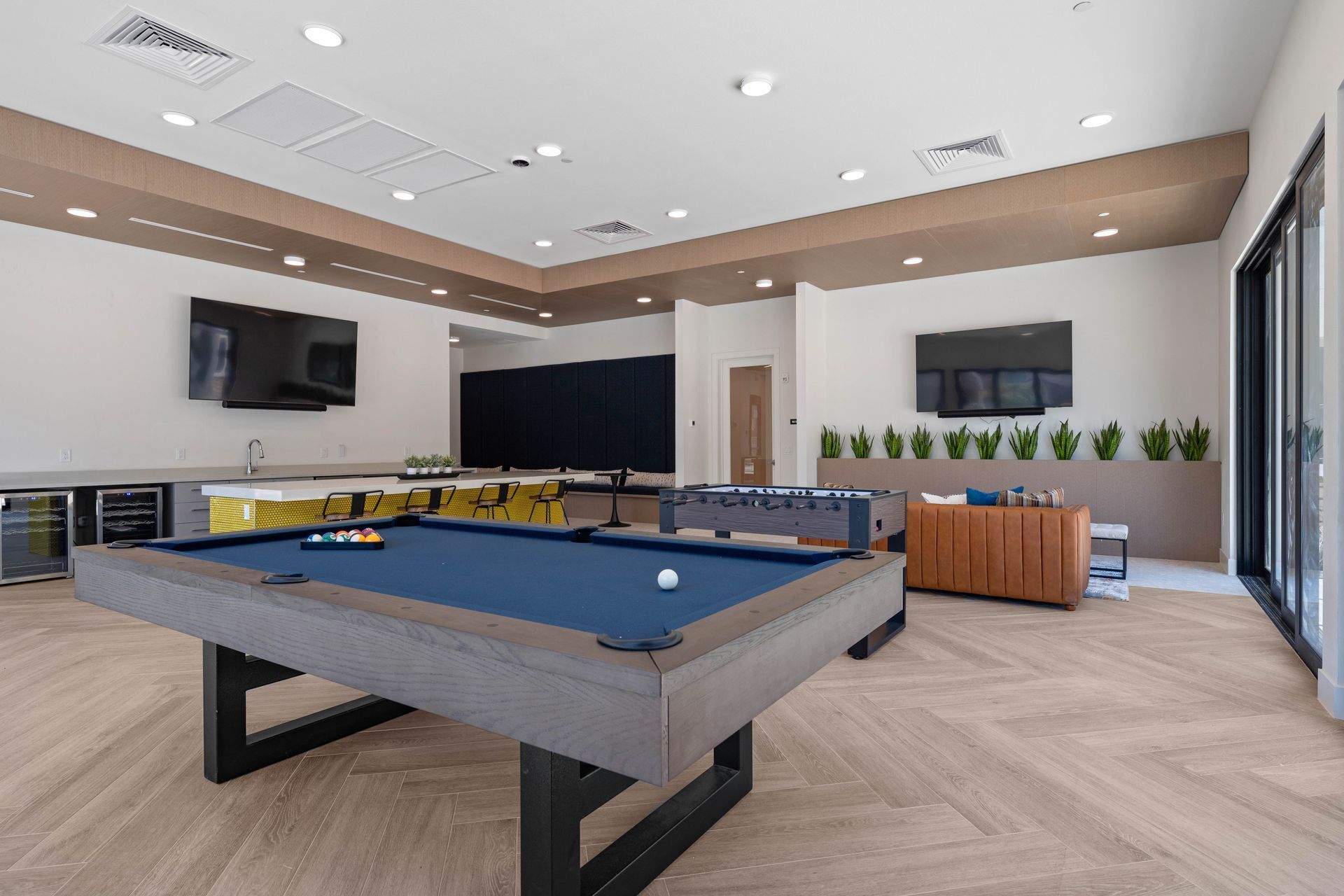 Game room with a pool table, foosball, TVs, and a wet bar.