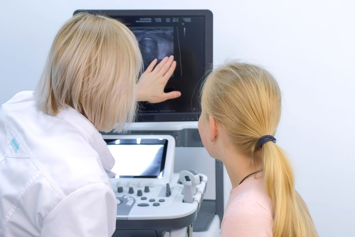 Un medico che mostra a una paziente le immagini di un'ecografia alla tiroide