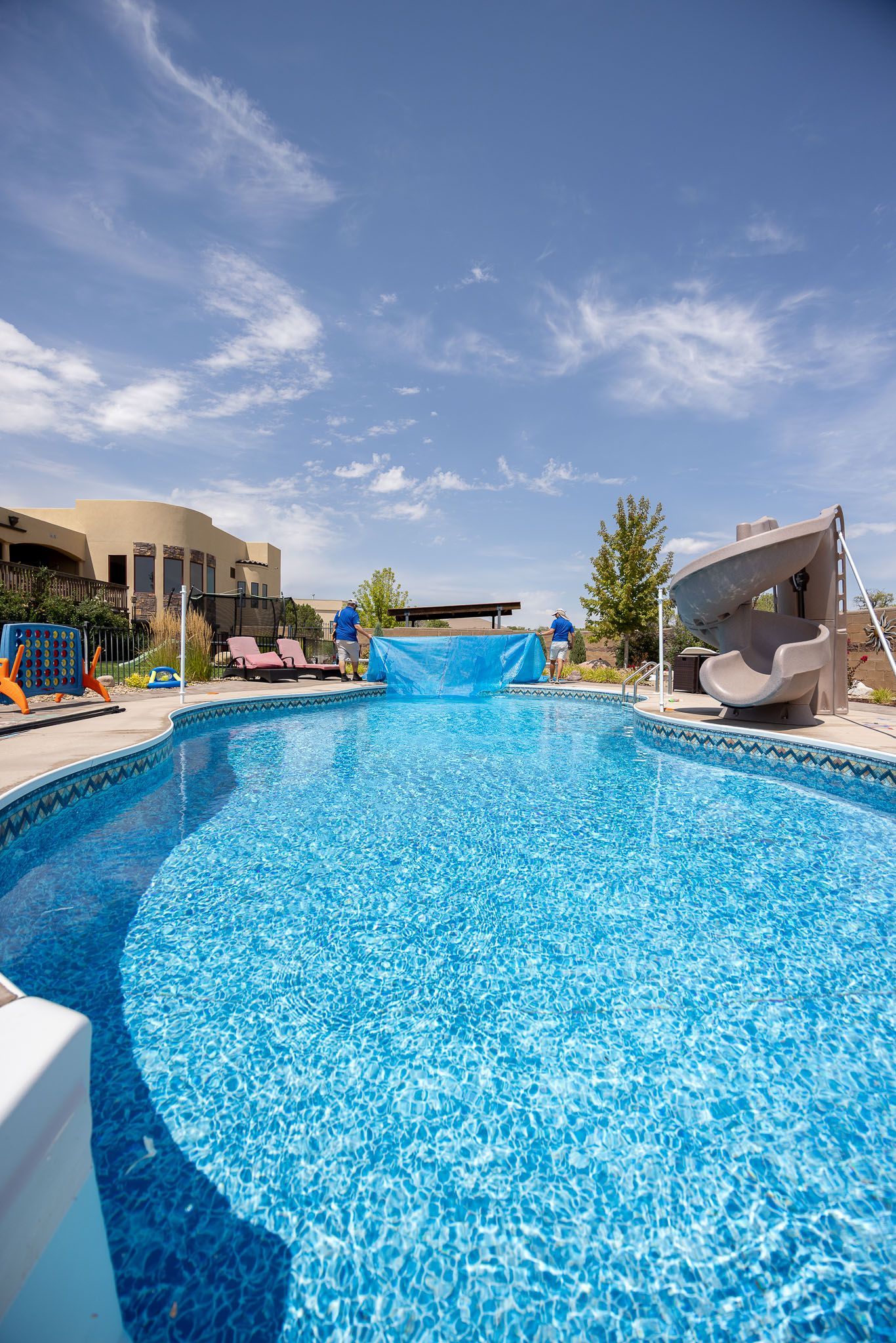 A swimming pool with blue tiles and a ladder in the water.