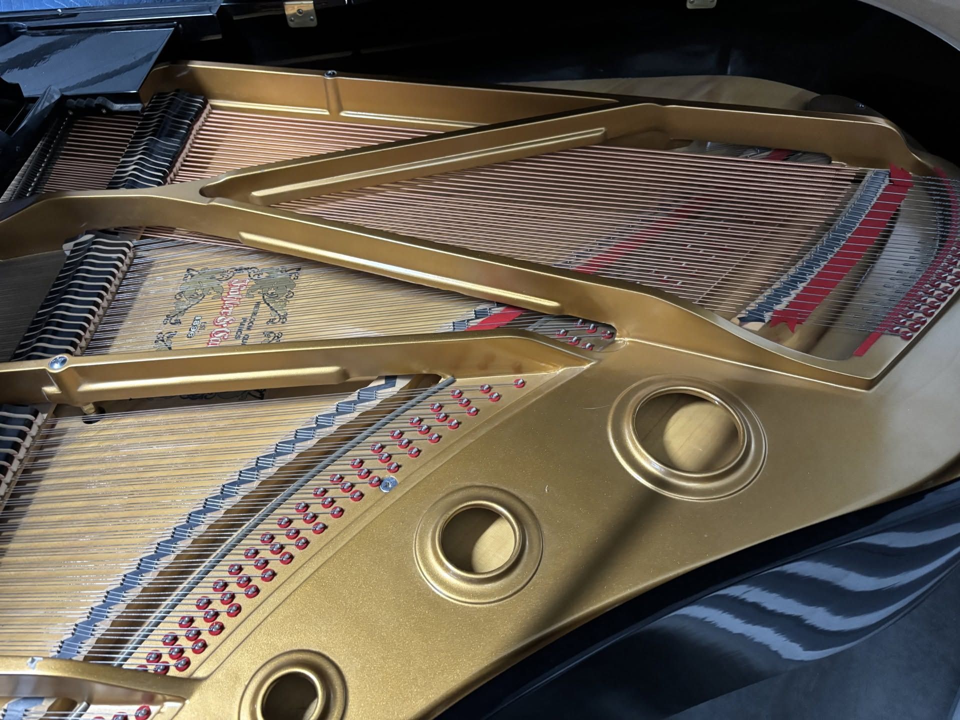 Gold-colored car dashboard with three round air vents and chrome trim on a patterned seat.