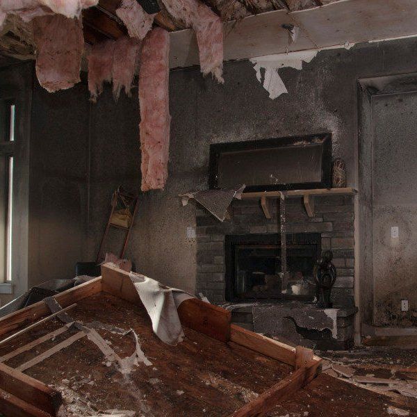A room with a fireplace and a lot of junk on the floor