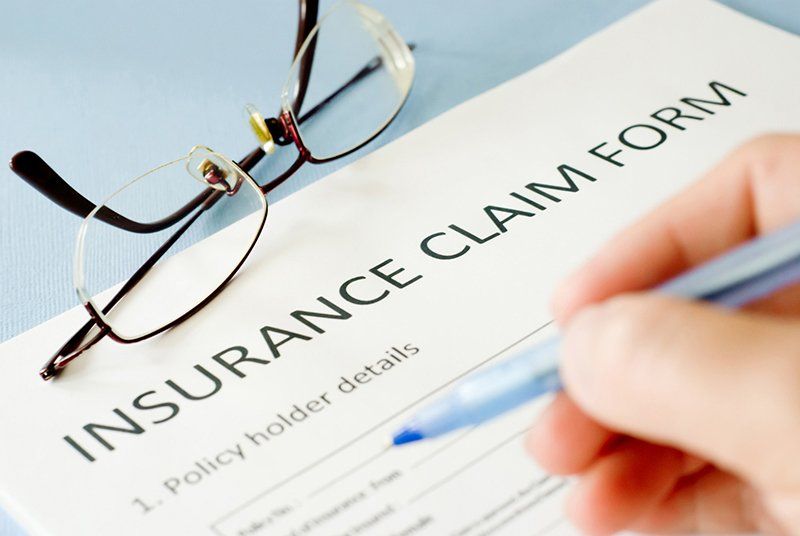 A person is filling out an insurance claim form