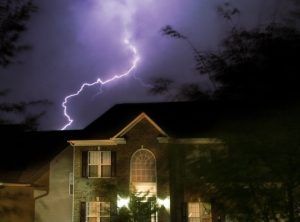 A lightning bolt strikes a house at night