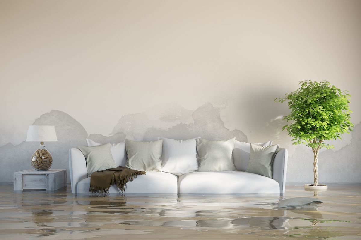 A living room with a white couch and a flooded floor.