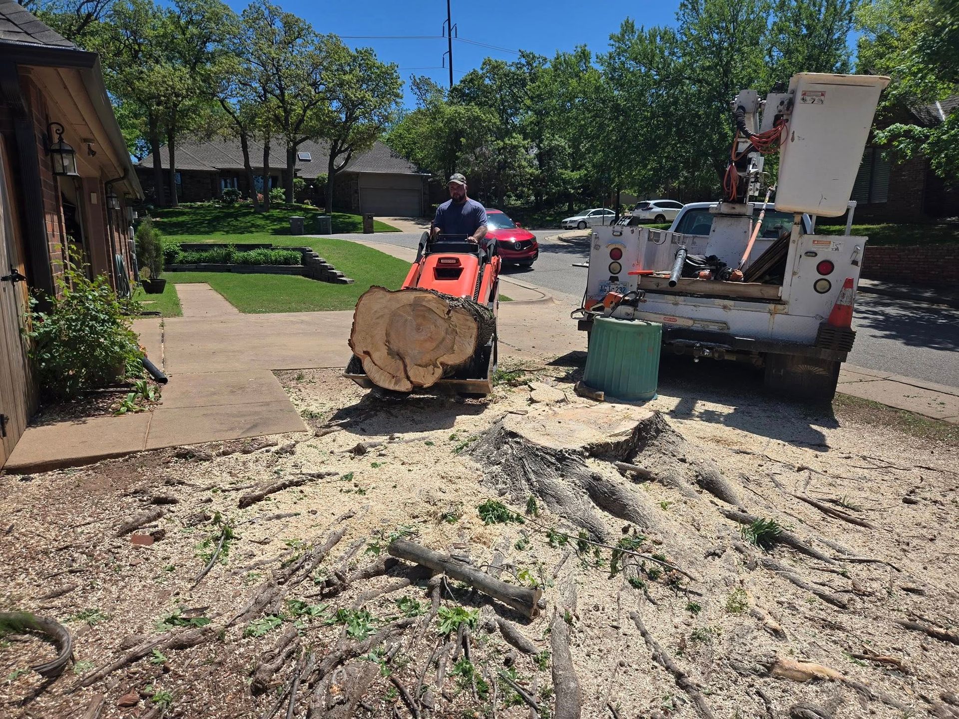 A man is cutting a tree stump with a machine.