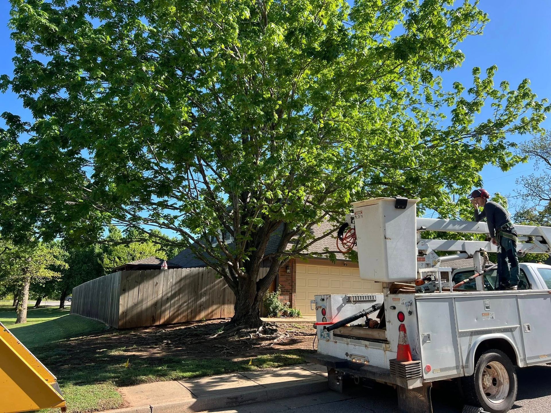 A man is standing on the back of a utility truck.