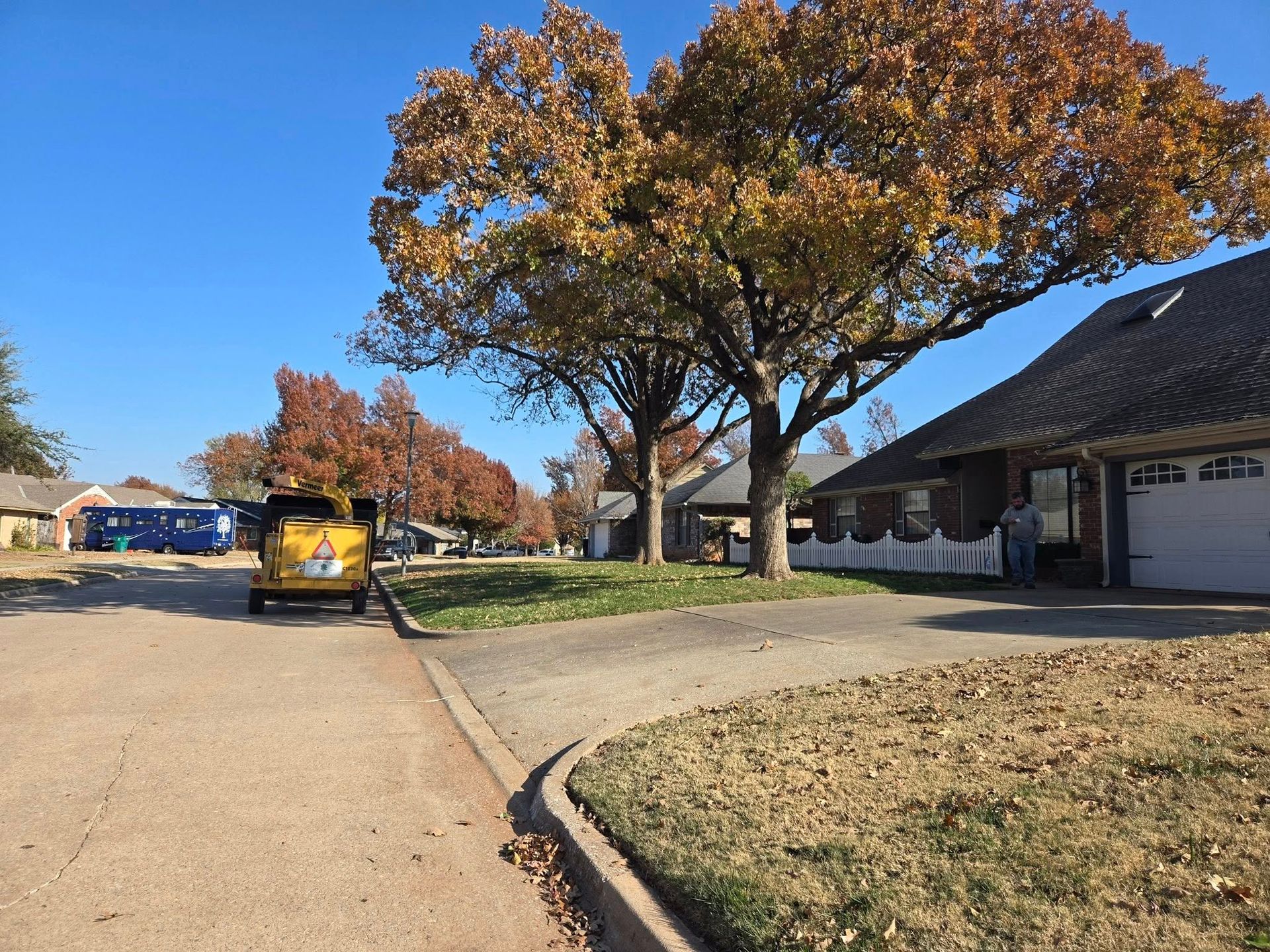 A yellow car is parked on the side of the road in a residential neighborhood