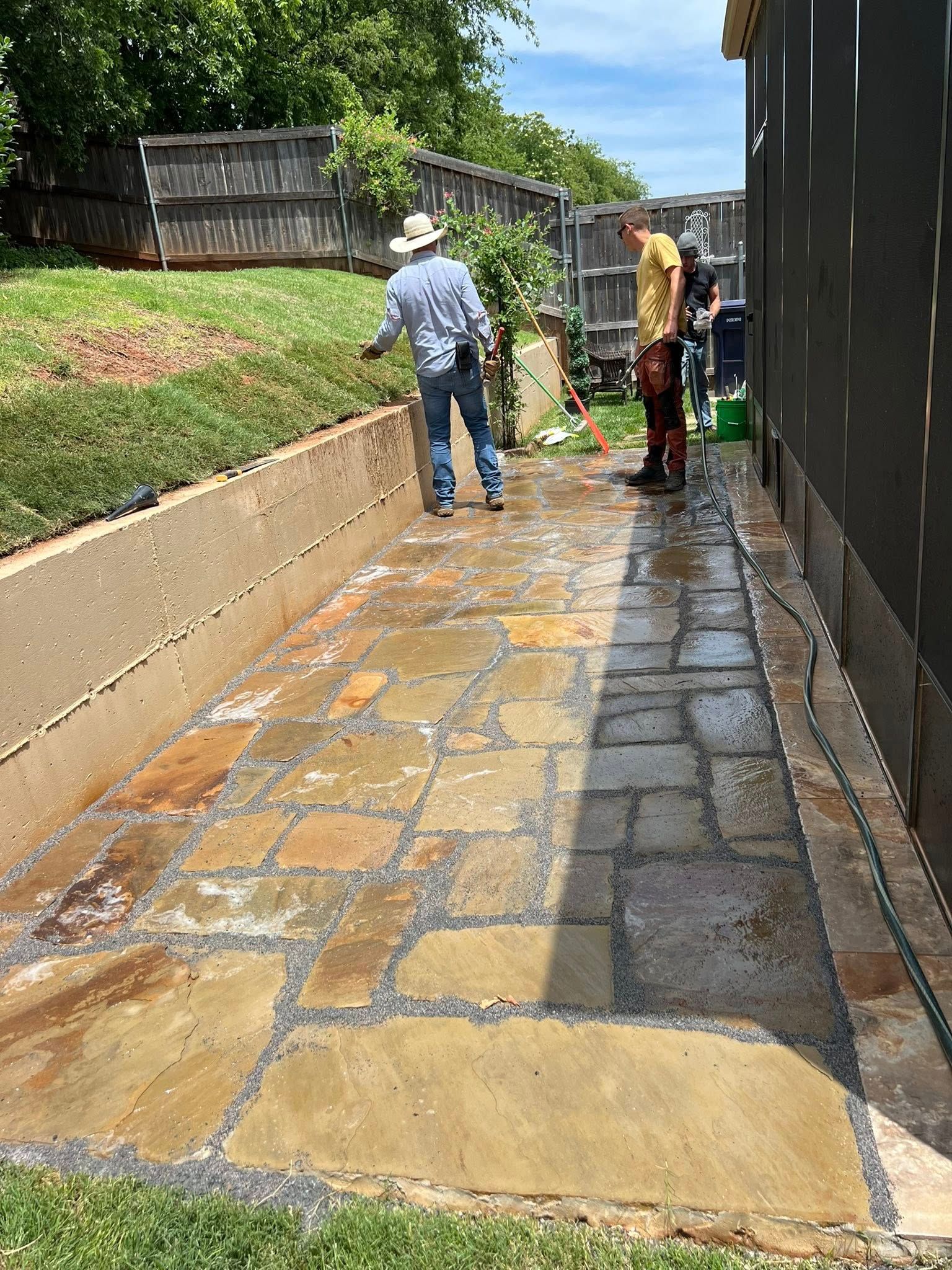 A group of people are cleaning a stone walkway.