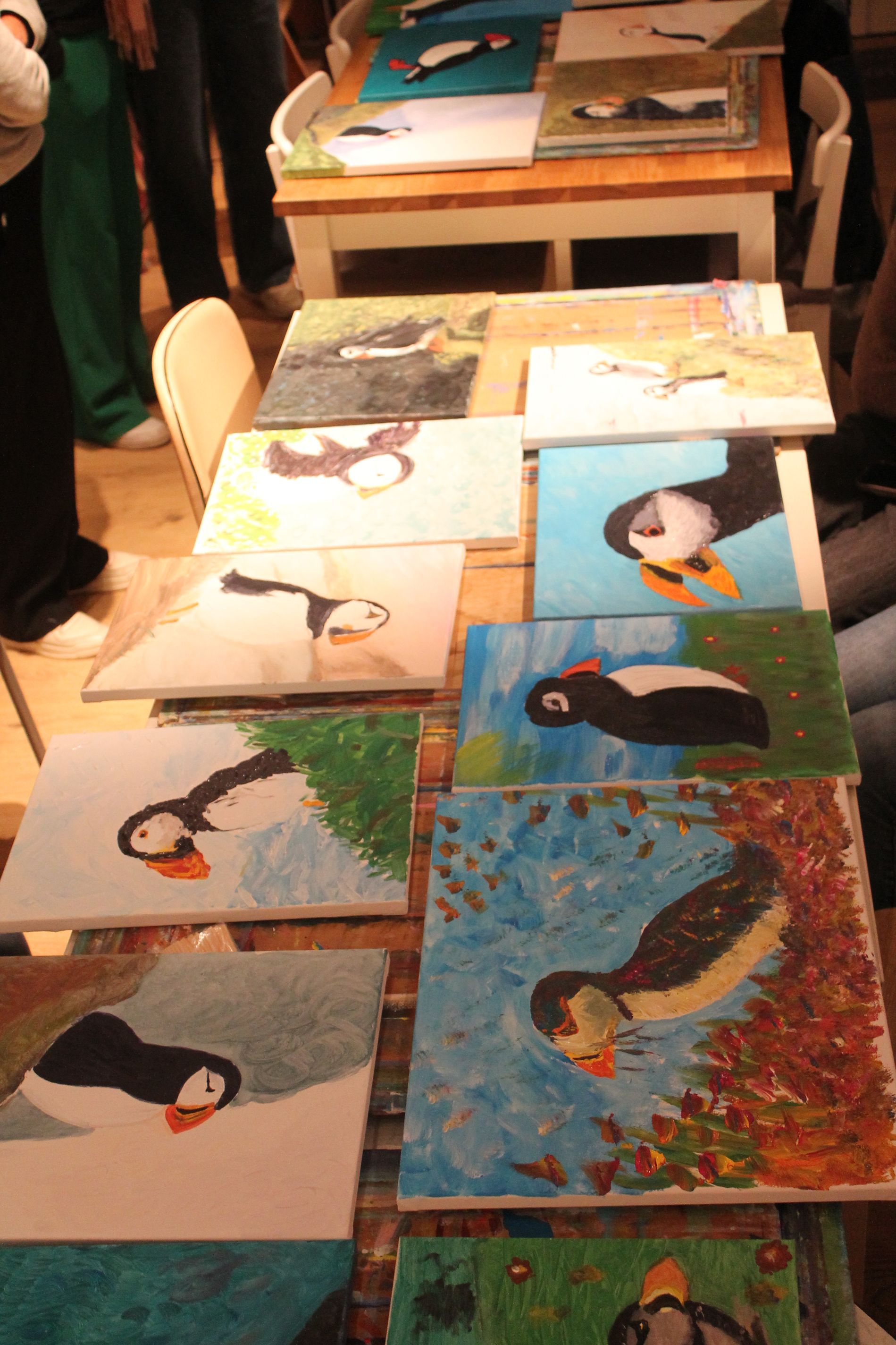 Een tafel met een heleboel schilderijen van puffins erop