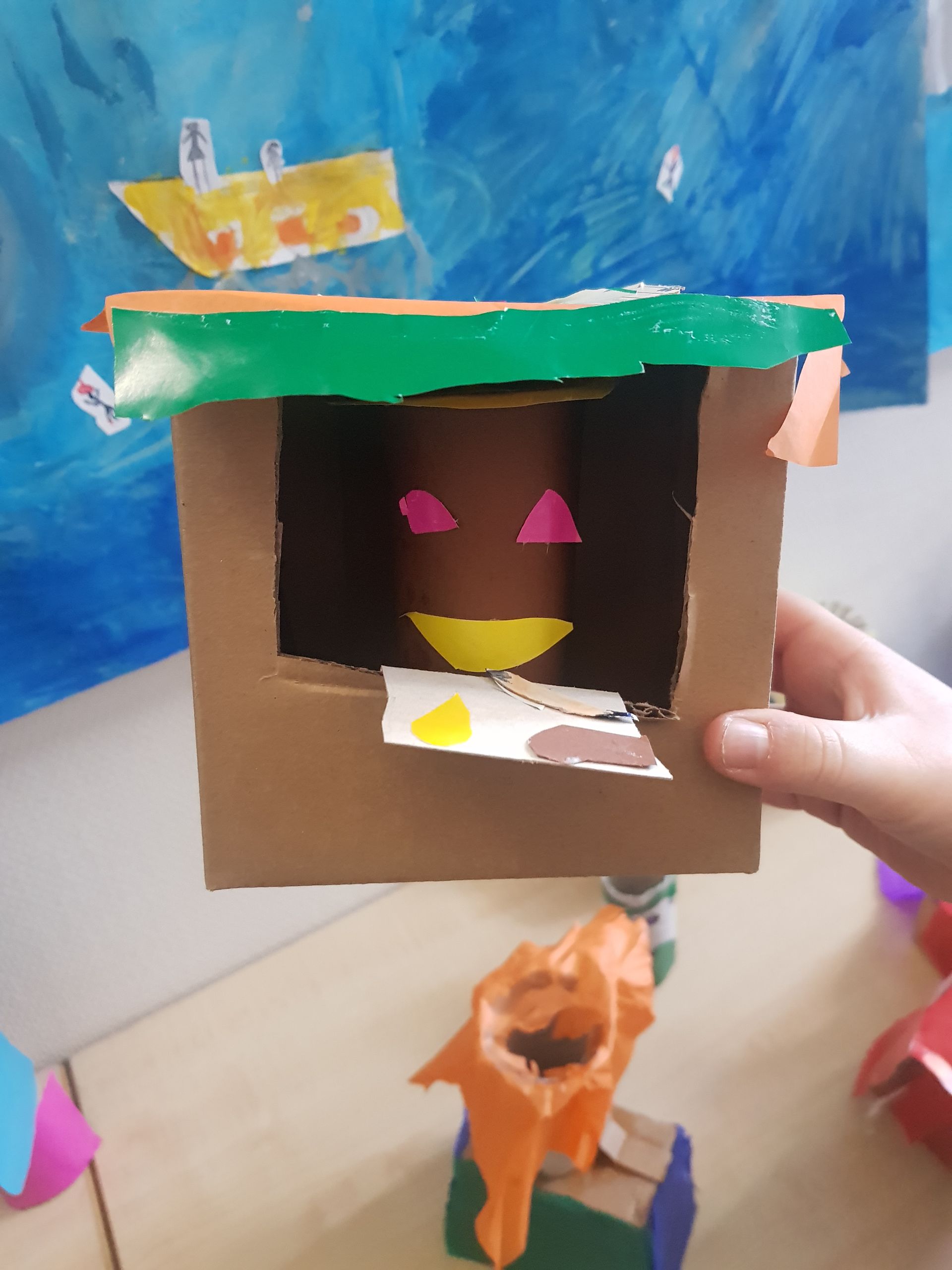 Een persoon houdt een kartonnen doos vast met een gezicht erop