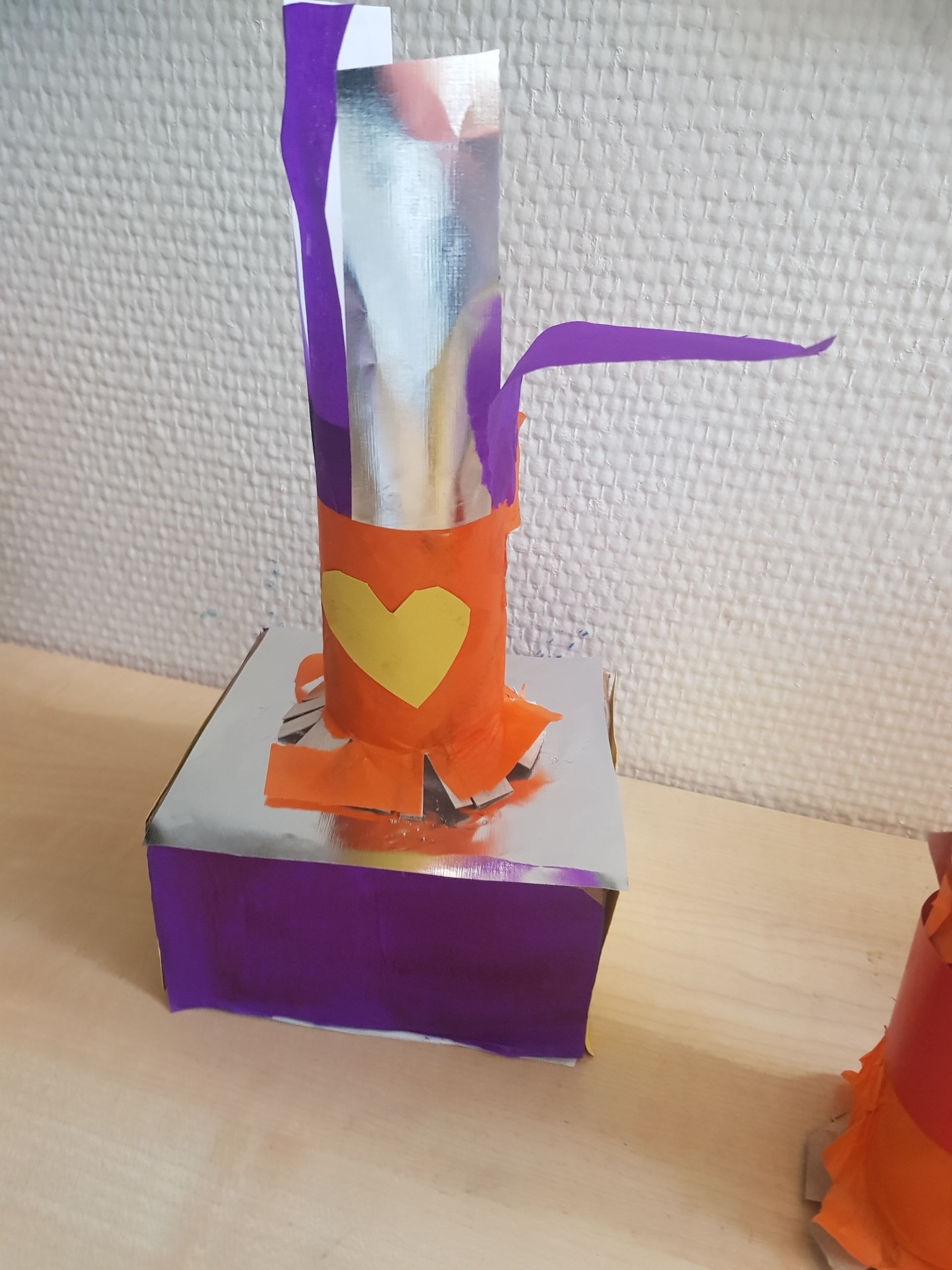 Een paarse doos met daarop een geel hart