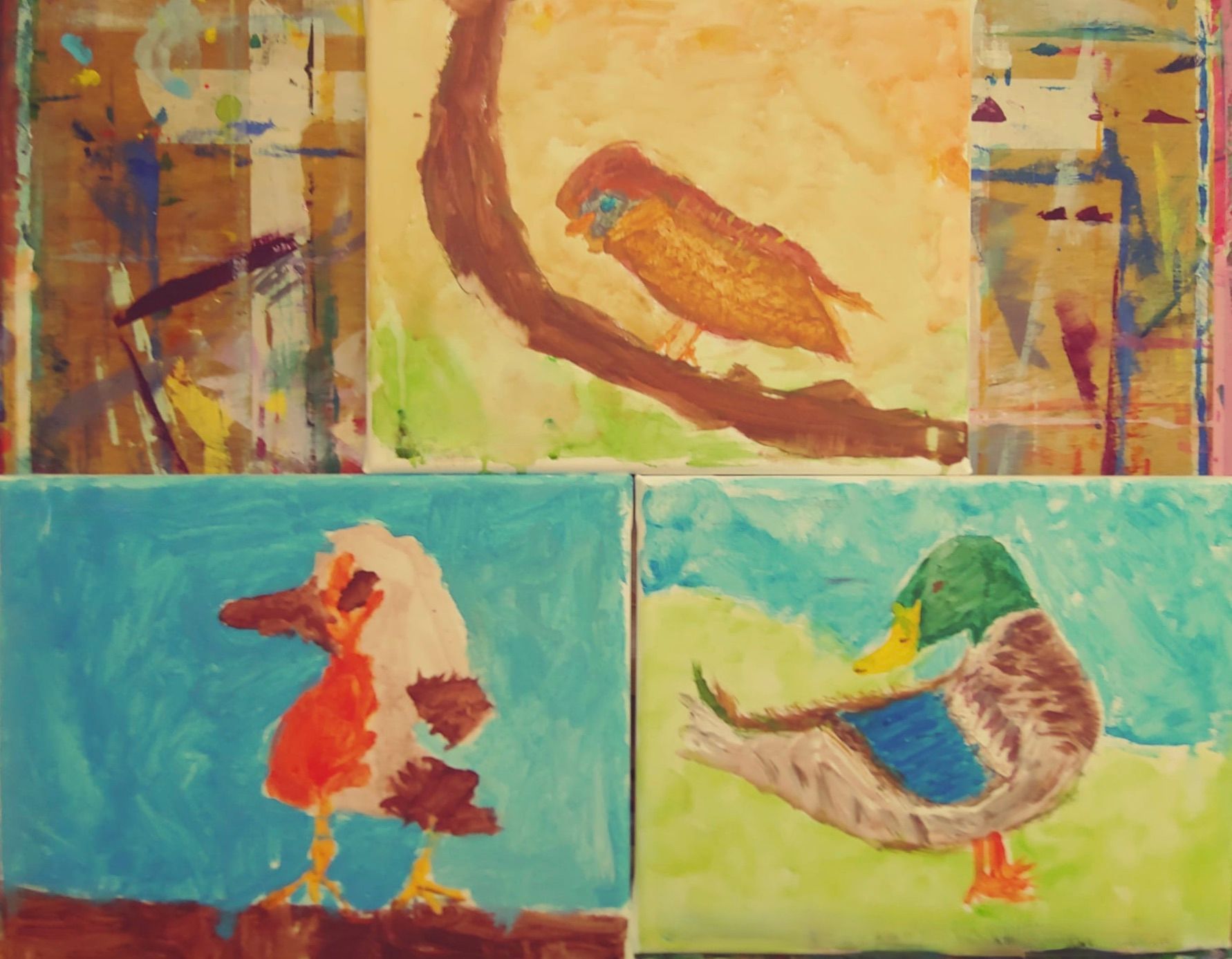 Op een schildersezel staan ​​drie schilderijen van vogels opgesteld