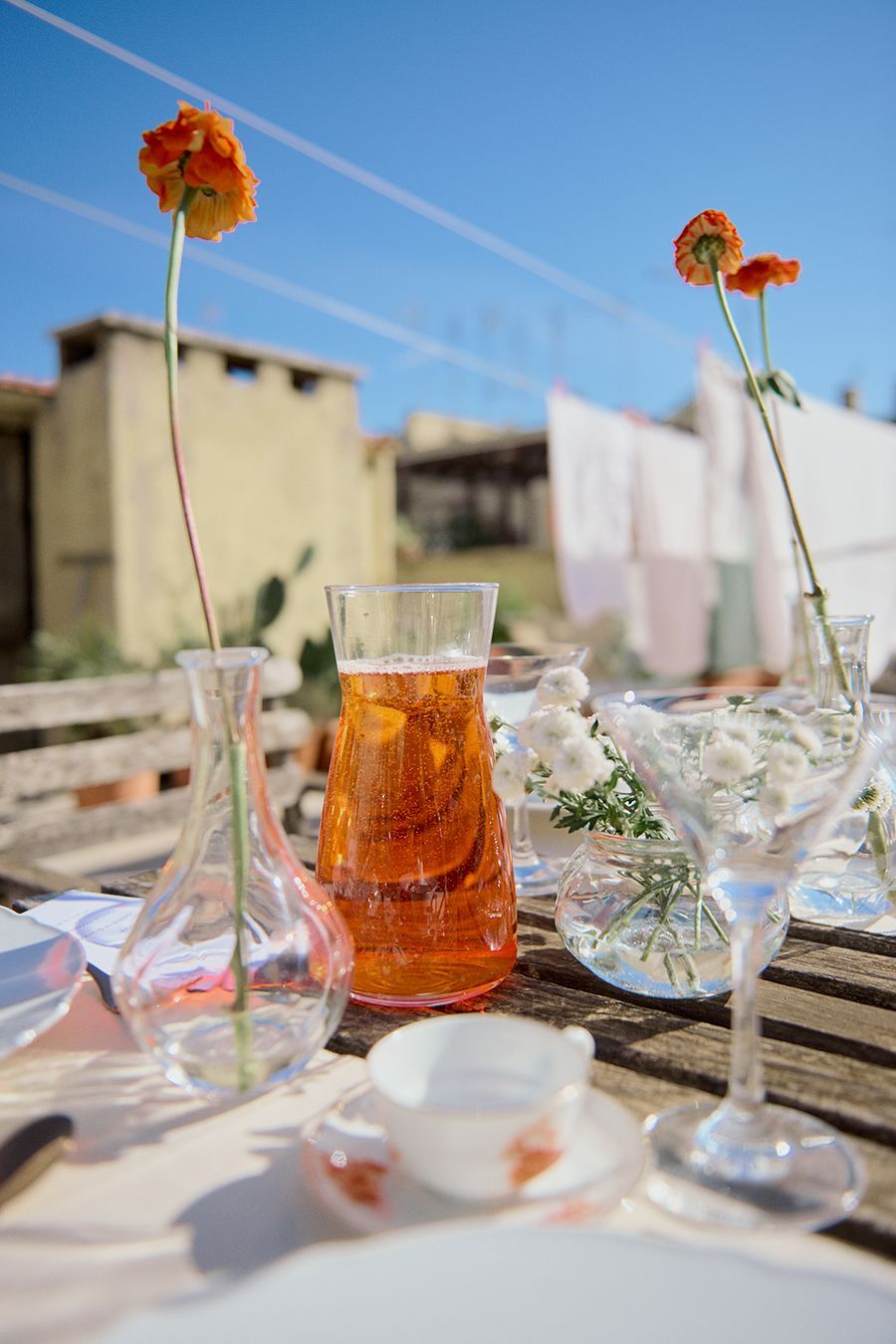 Un tavolo con bicchieri, vasi e fiori sopra.
