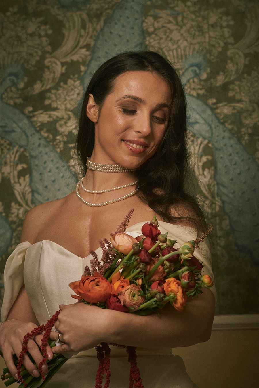 Una donna in abito da sposa tiene in mano un mazzo di fiori.
