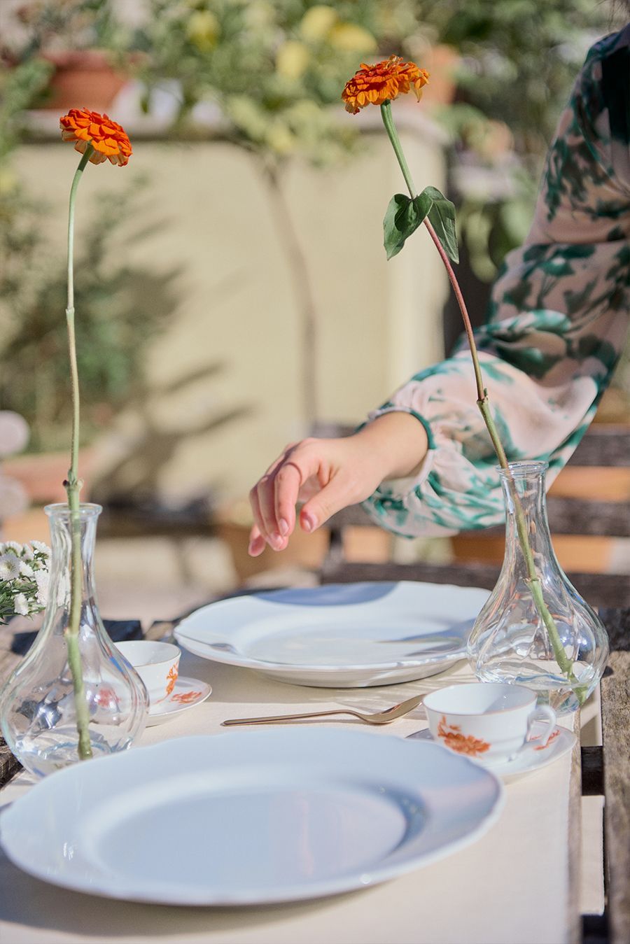 Una persona sta mettendo un fiore in un vaso su un tavolo.