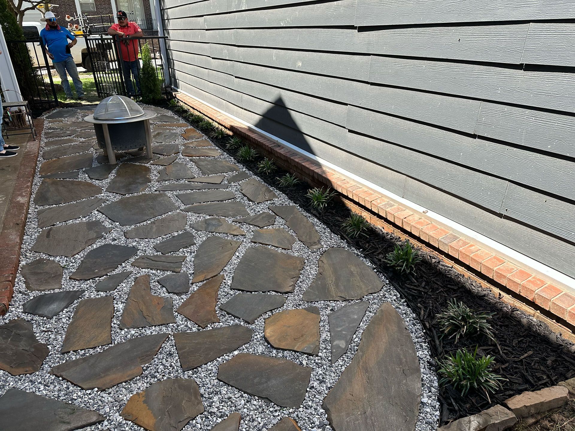 A stone walkway is being built in front of a house.